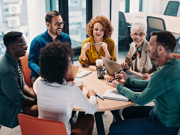 Group of business people having a meeting at a round conference table in a creative office. 