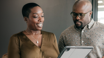 Two professionals discussing a laptop presentation