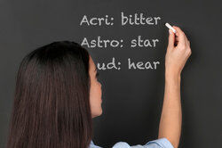 Teacher writing root words on board