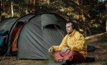 Man listening to headphones outside tent