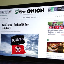 In this photo illustration, The Onion website is displayed on a computer screen, showing a satirical story titled Here’s Why I Decided To Buy ‘InfoWars’,