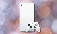 robot white xbox series x console and controller against a light purple and orange circular background