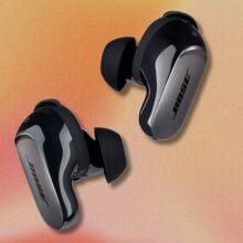 bose quietcomfort ultra earbuds on an orange and red swirling background