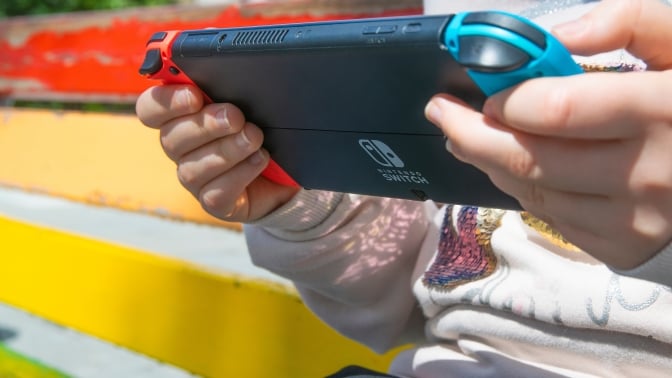 Person holding Nintendo Switch handheld console