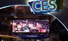 People walking on a conference center below a CES sign.