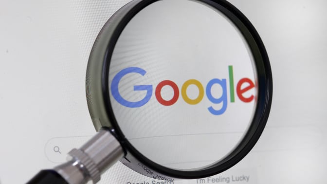 Google logo behind magnifying glass