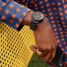 pixel watch 2 on a wrist of a person sitting on a yellow bench