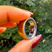 Woman holding Oura Ring 4 in between her thumb and pointer finger