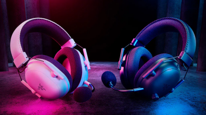 black and white Razer BlackShark V2 Pro headsets in a dark warehouse-style room lit by pink and blue lighting