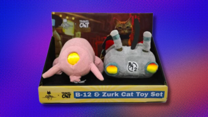 the B-12 & Zurk Cat Toy Set by Stray x Travel Cat in its packaging against a blue, purple, and orange abstract background