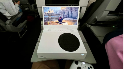 a first-person view of someone playing a game on an airplane using an xbox series s with a uspec gaming xscreen attached to it