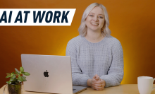 smiling woman in front of a laptop with an orange backdrop behind her