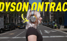 a woman crossing a busy street wearing the Dyson Ontrac headphones