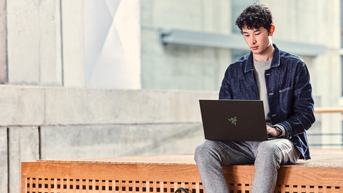 Male student outside on the go working on RazorBlade.