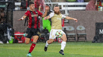 Birmingham Legion FC midfielder Enzo Martinez fights for the ball with Atlanta United FC defender Nick Firmino during a 2024 preseason match at Protective Stadium.