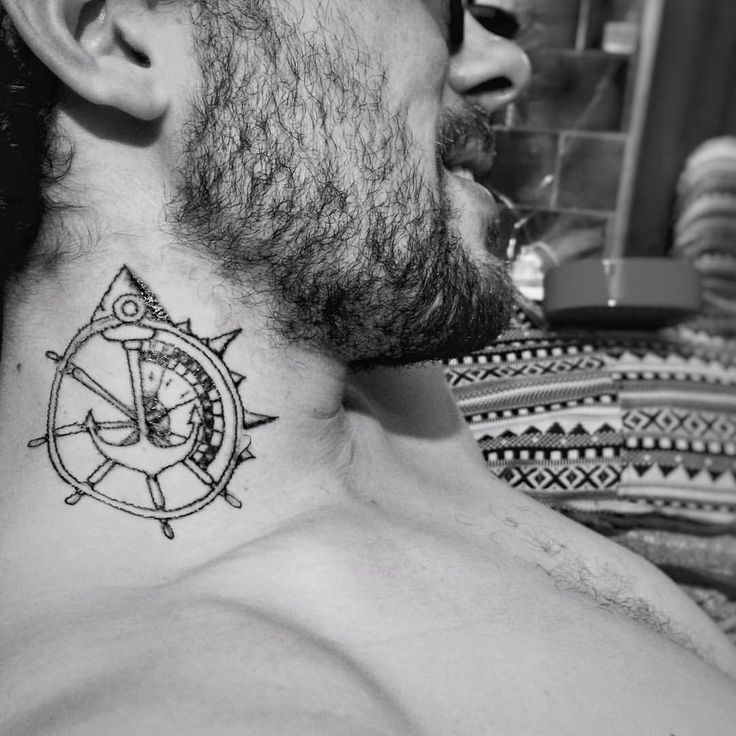 a man with a compass tattoo on his neck