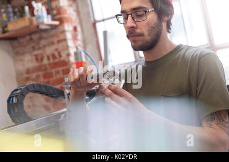 Männliche Designer über Bremssättel in Werkstatt Stockfoto