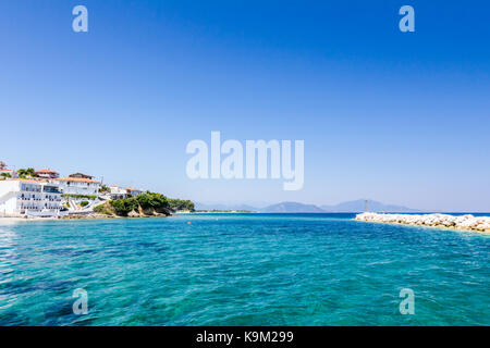 Felsige Untiefen mit kristallklarem Wasser und schönen Siedlung über blaue Meer. Stockfoto