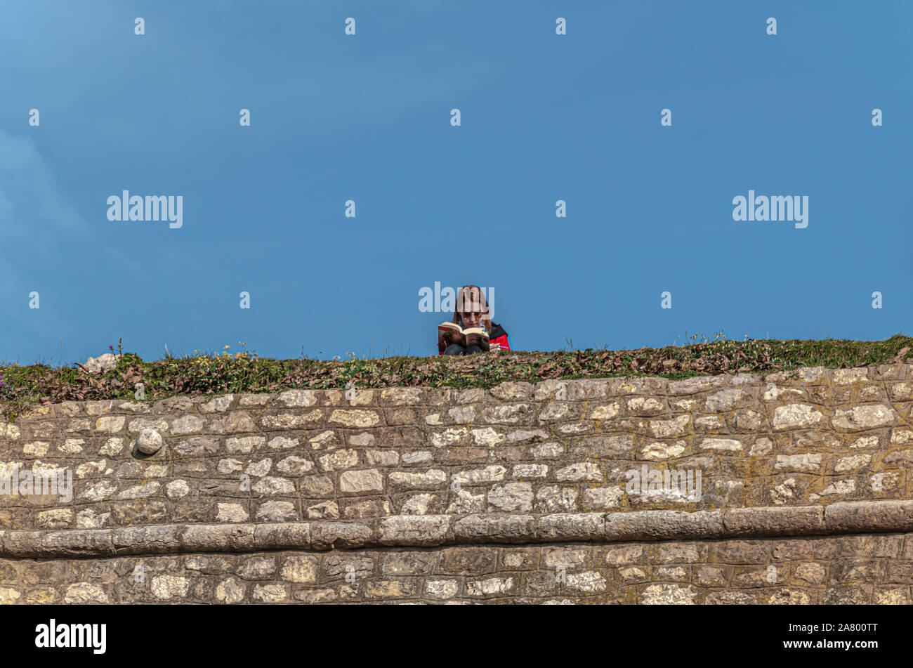 Girl reading book on Yellow Bastion Stock Photo