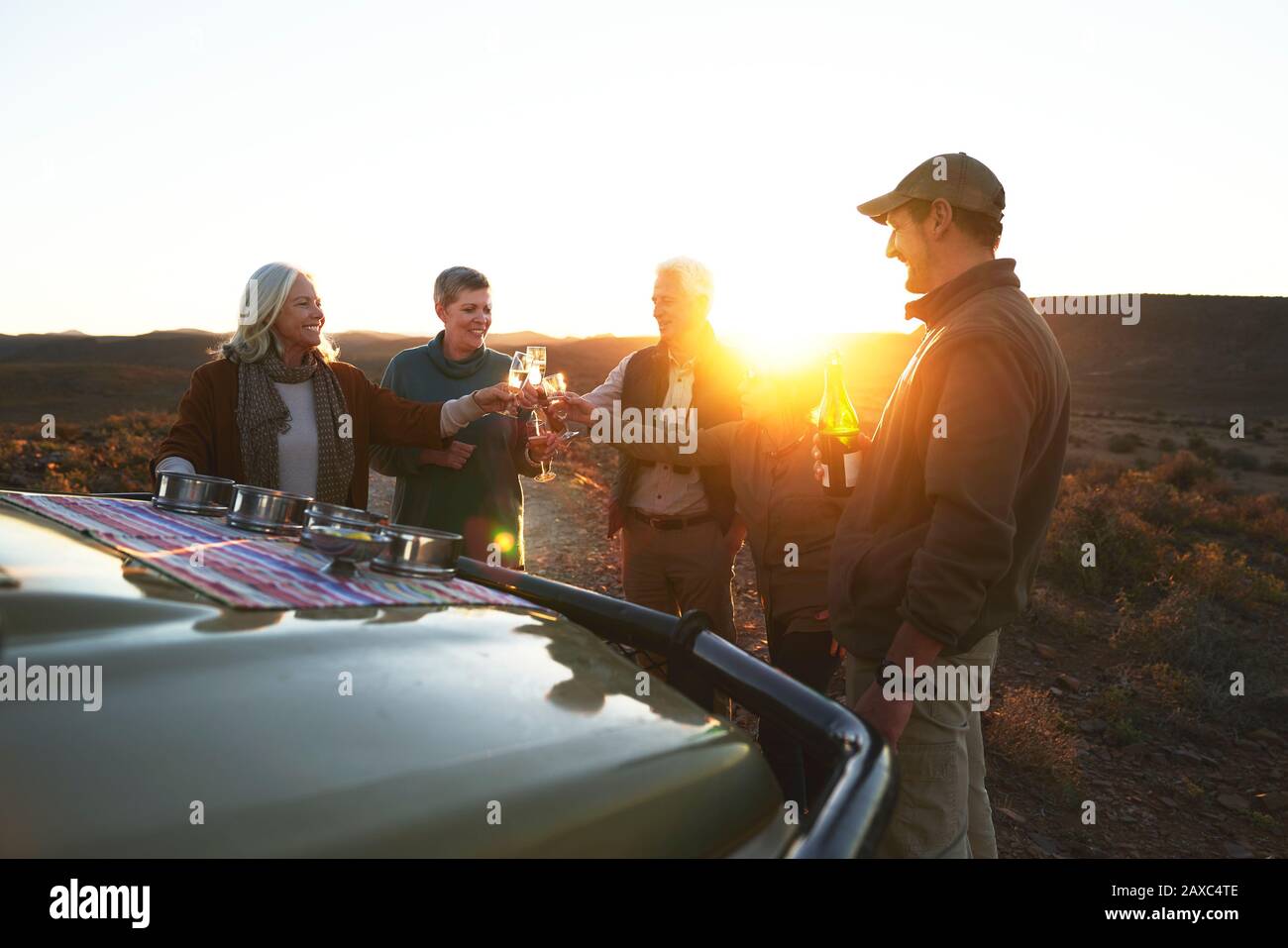 Safari tour group toasting champagne glasses on sunset Stock Photo