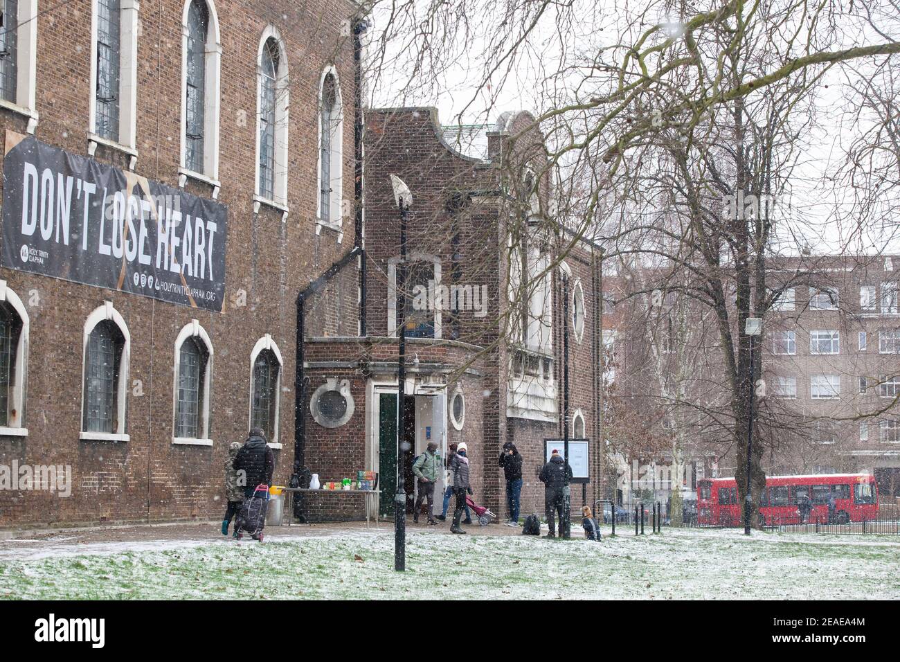 London, UK. 9th Feb, 2021. At Holy Trinity church on Clapham Common a food bank runs an outdoor collection service and hot drinks under a banner saying 'Don't lose heart.' After three days of snow in London it is starting to settle and winds have dropped as Storm Darcy has passed. Credit: Anna Watson/Alamy Live News Stock Photo