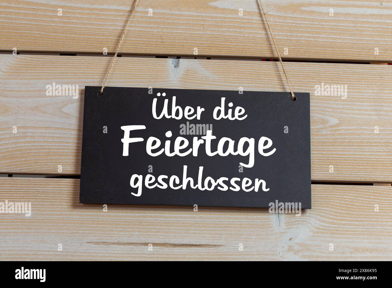 Symbol image of company holidays: Sign on a wooden board with the german inscription ÜBER DIE FEIERTAGE GESCHLOSSEN (closed over the public holidays) Stock Photo