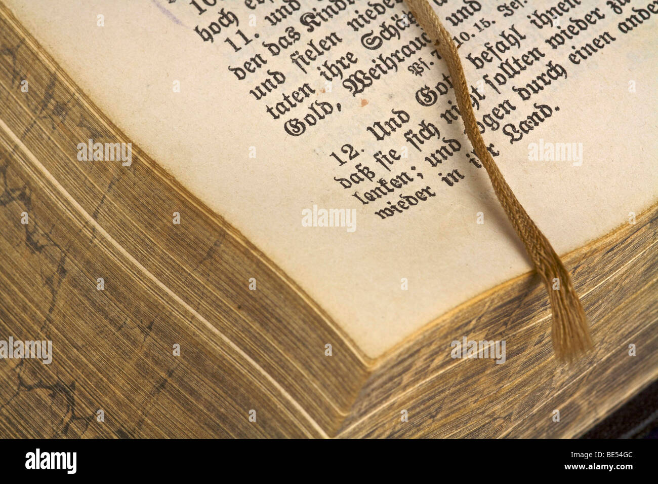 Open, one hundred years old Bible with a worn ribbon Stock Photo