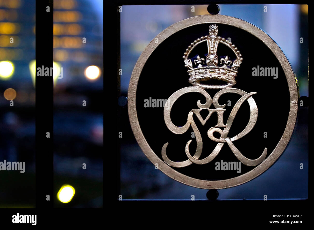 The royal emblem of George the Sixth on the gate of Tower at dusk Stock Photo