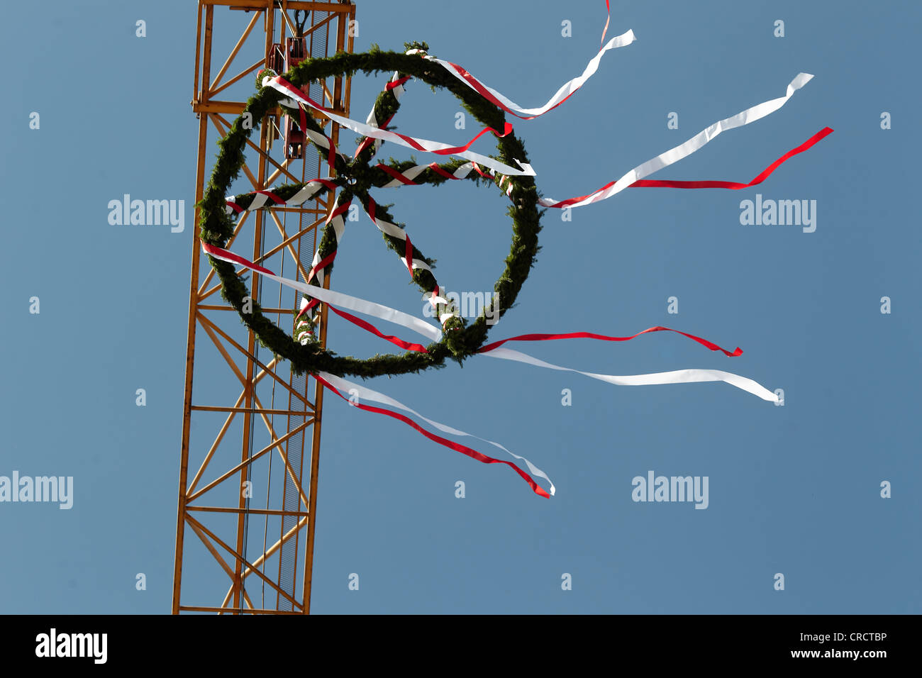 Topping-out ceremony at building site, wreath hanging on a crane Stock Photo