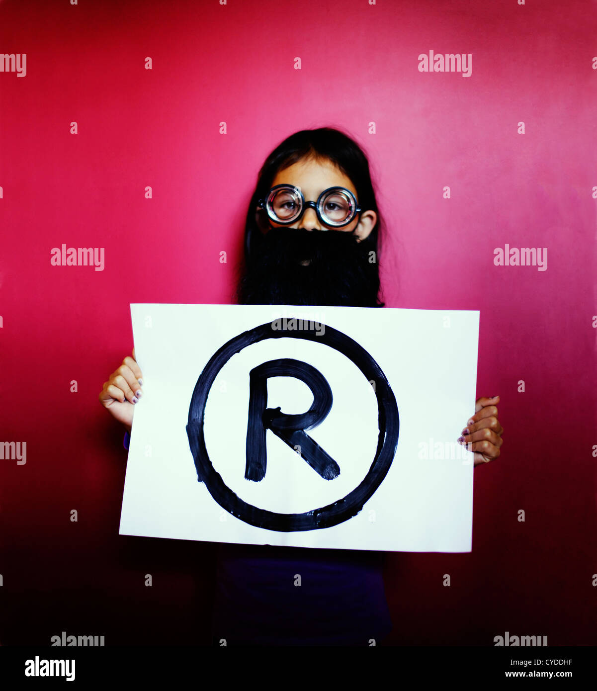 The professor says, 'Hands off: it's a Registered trademark'. Girl with fake beard and glasses holds trademark symbol. Stock Photo