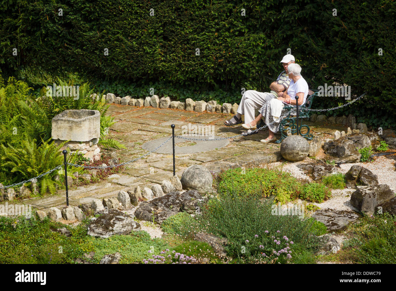 Elderly couple sat relaxing on a bench in Brodsworth Hall Gardens, Doncaster, South Yorkshire. Stock Photo