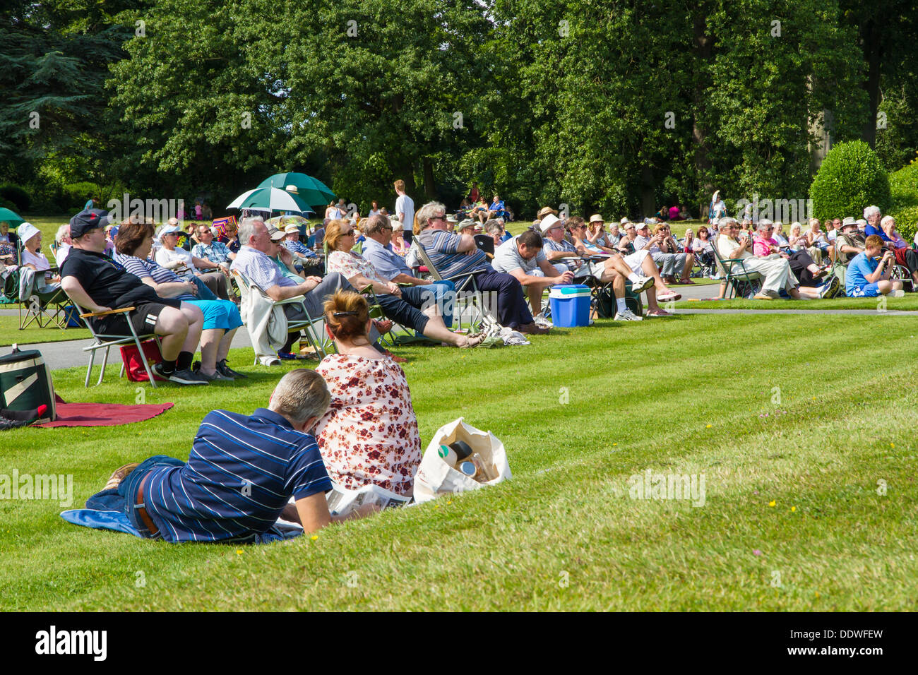 Visitors to Brodsworth Hall in Doncaster sat on the lawn in the sunshine listening to the afternoon band concert. Stock Photo