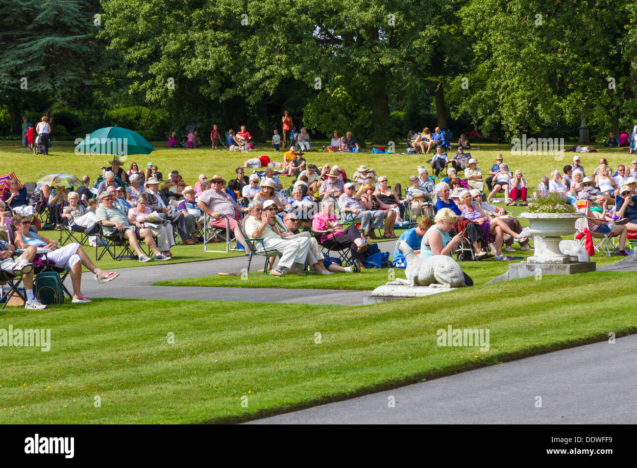 Visitors to Brodsworth Hall in Doncaster sat on the lawn in the sunshine listening to the afternoon band concert. Stock Photo