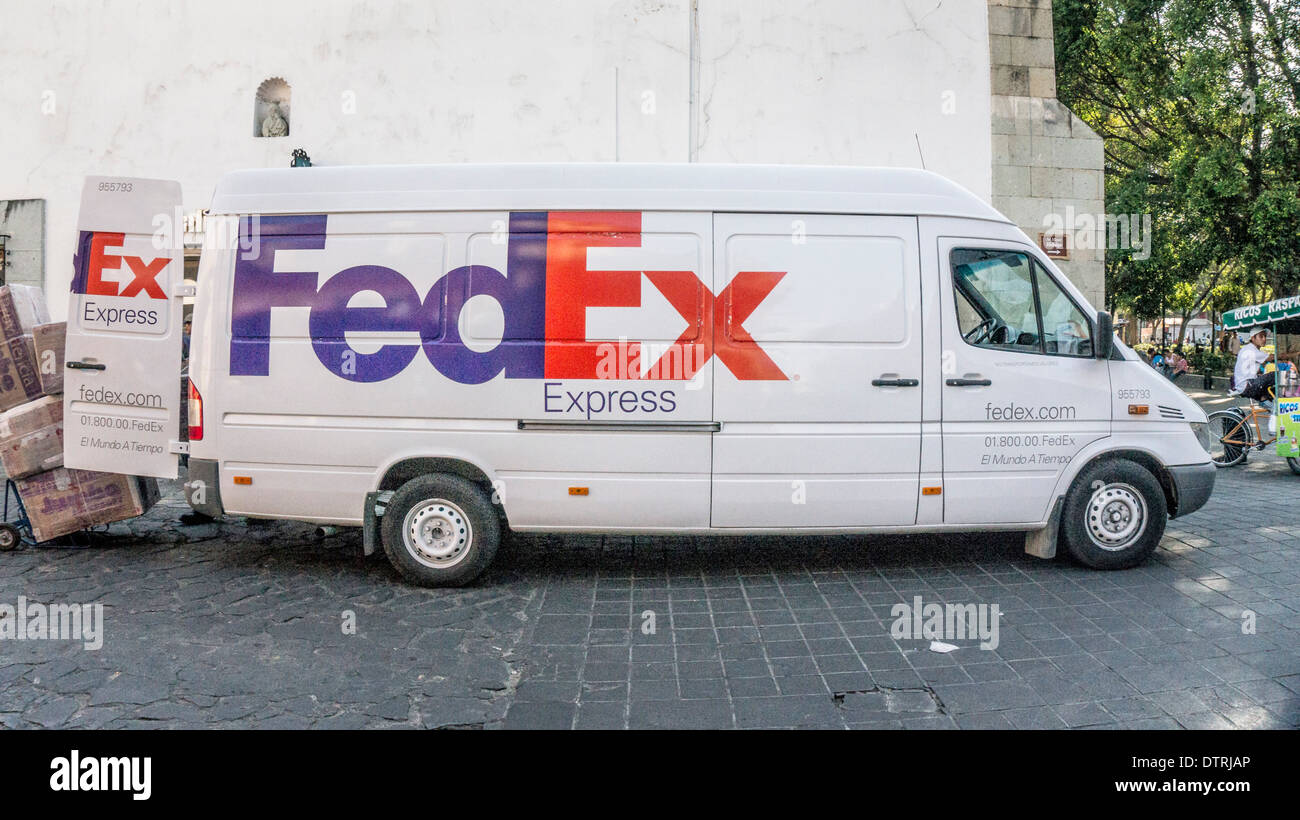 large sleek Fedex truck making delivery on Avenida Miguel Hidalgo paved with cobblestones at northeast corner of Zocalo Oaxaca Stock Photo