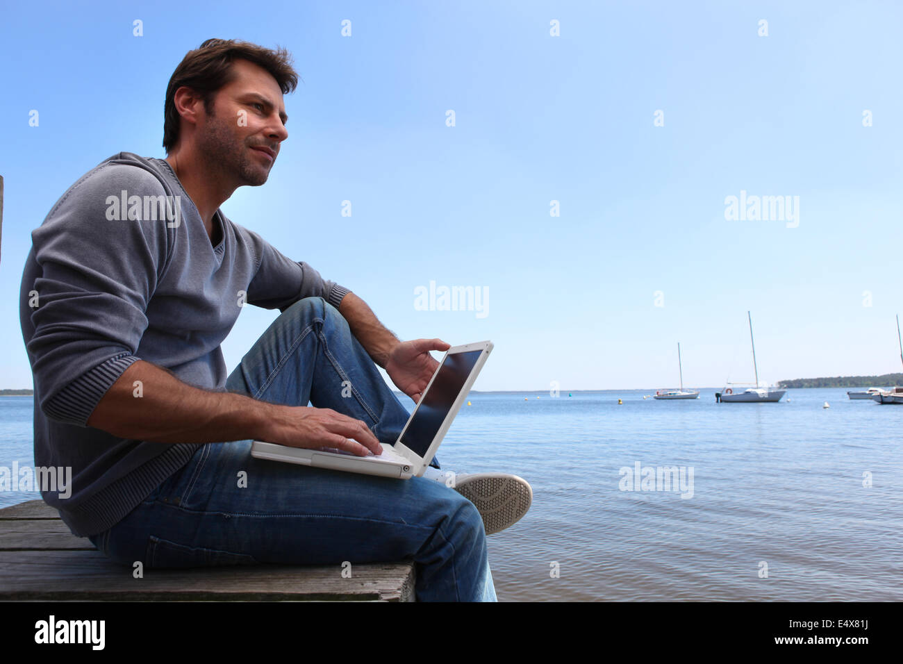 Man sat by lake Stock Photo