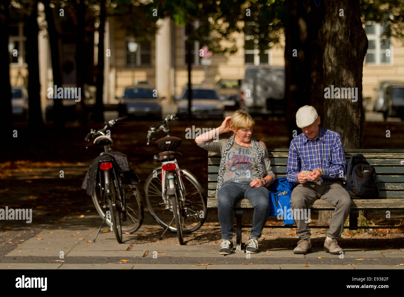 couple sat on bench next to bicycles tourists tour Stock Photo