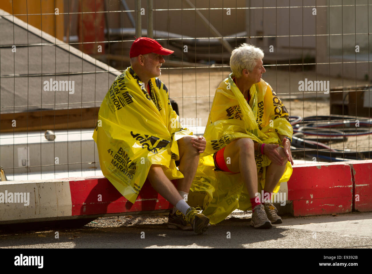 Marathon runners sat street after race old couple Stock Photo