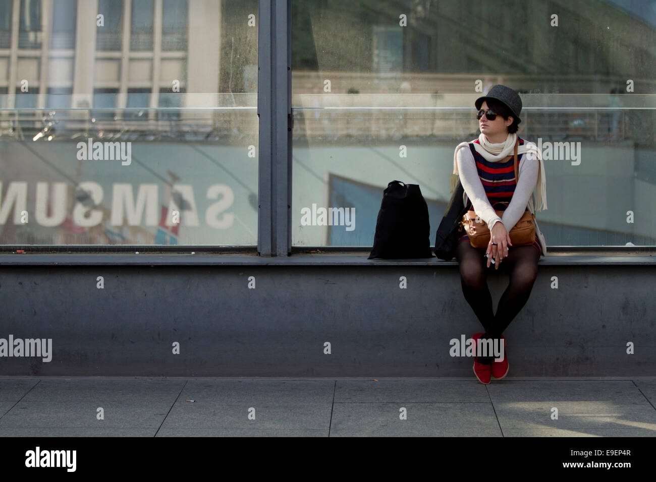 lady hat sunglasses red shoes waiting sat street Stock Photo