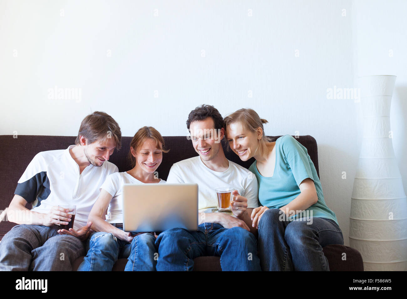 group of friends watching tv and smiling Stock Photo