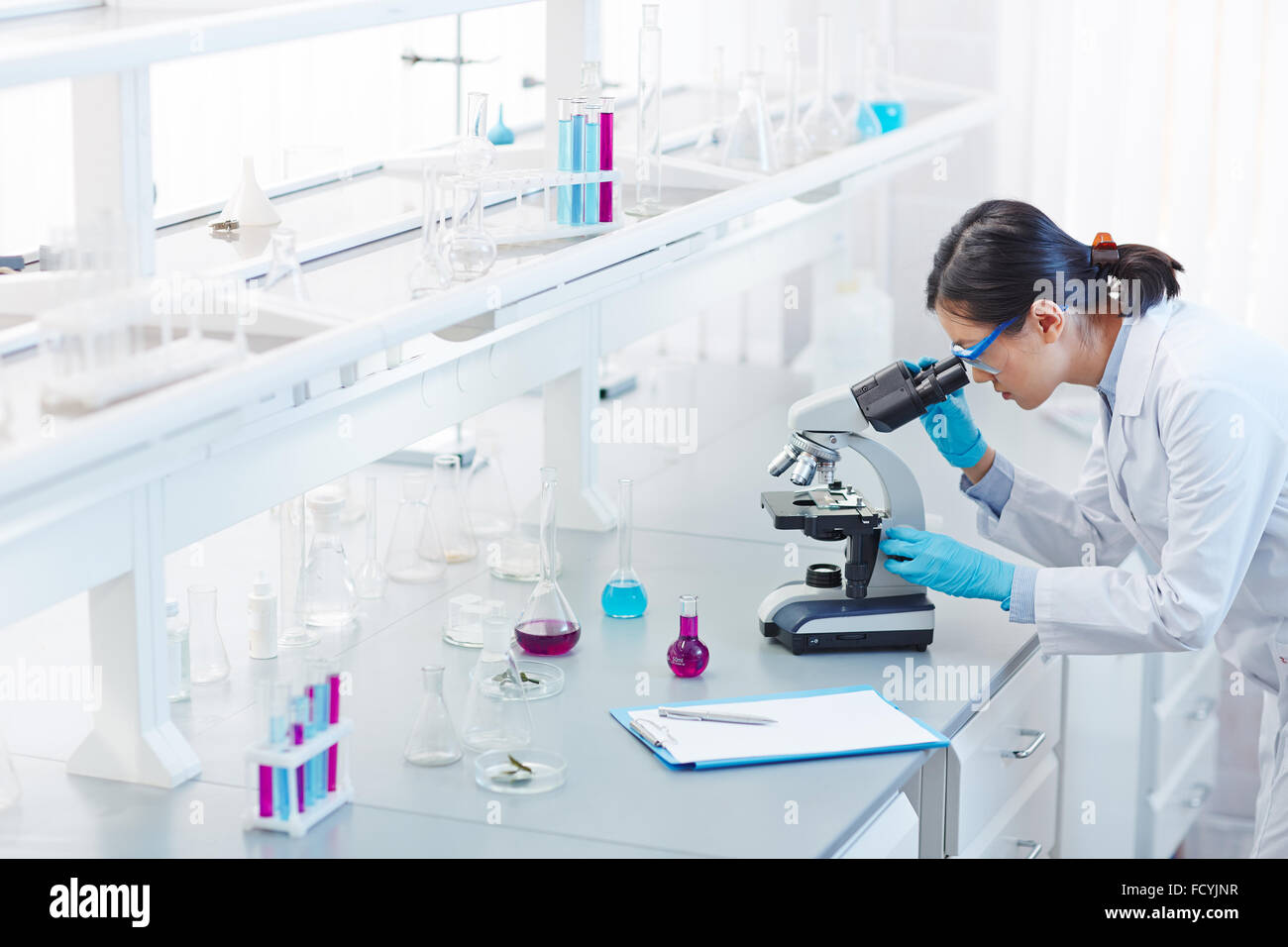 Glassware, microscope and clipboard in scientific laboratory Stock Photo