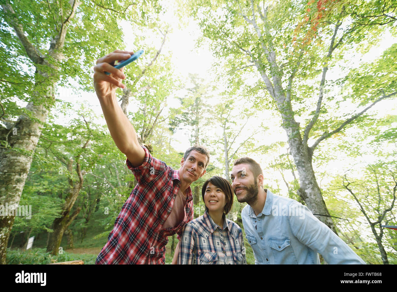 Multi-ethnic group of friends taking selfie at a camp site Stock Photo