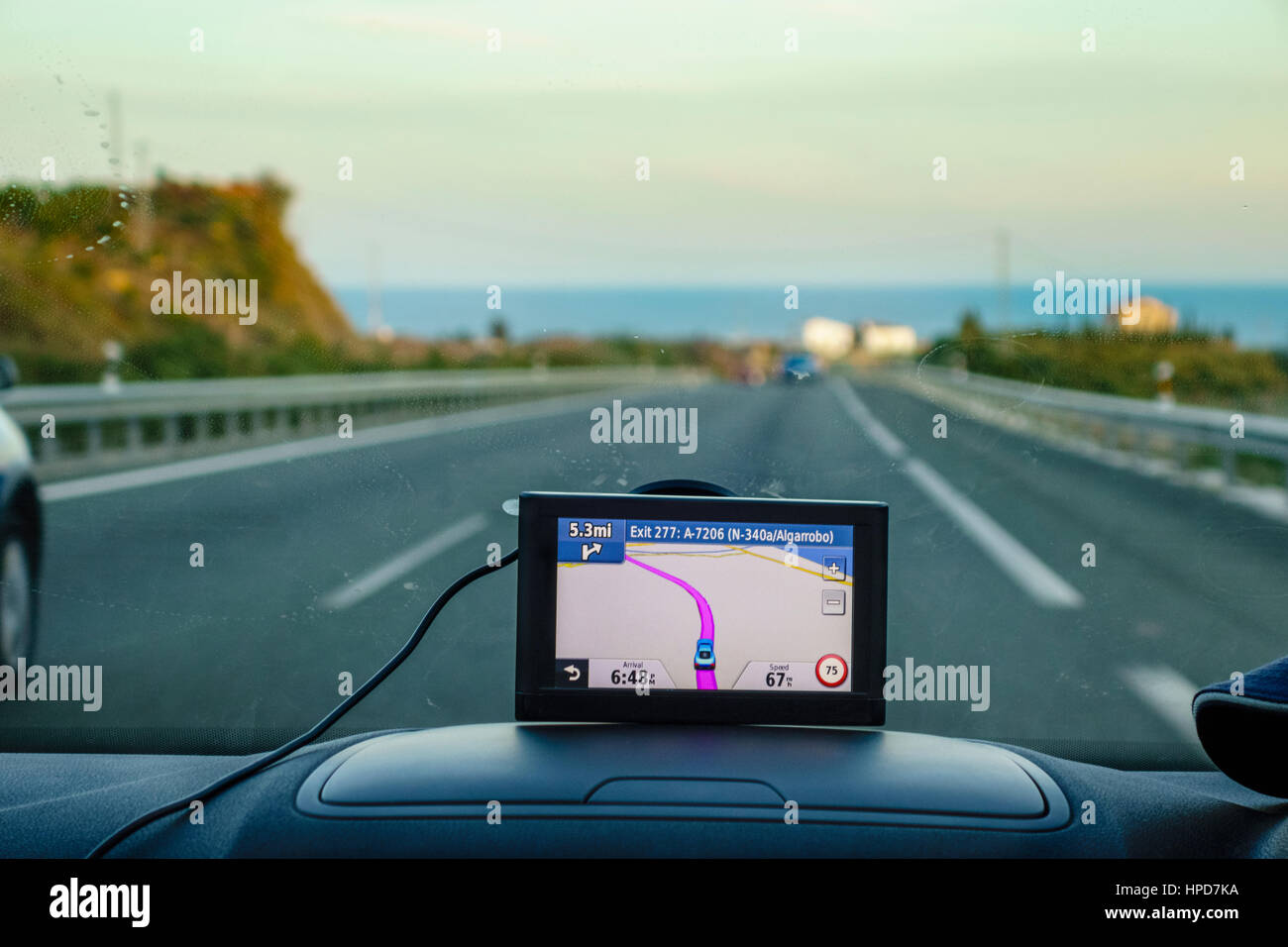 Satnav, Sat nav, or gps satellite navigation in car. UK car with satnav on dashboard Costa del Sol Spain. Looking out over the Mediterranean. Stock Photo