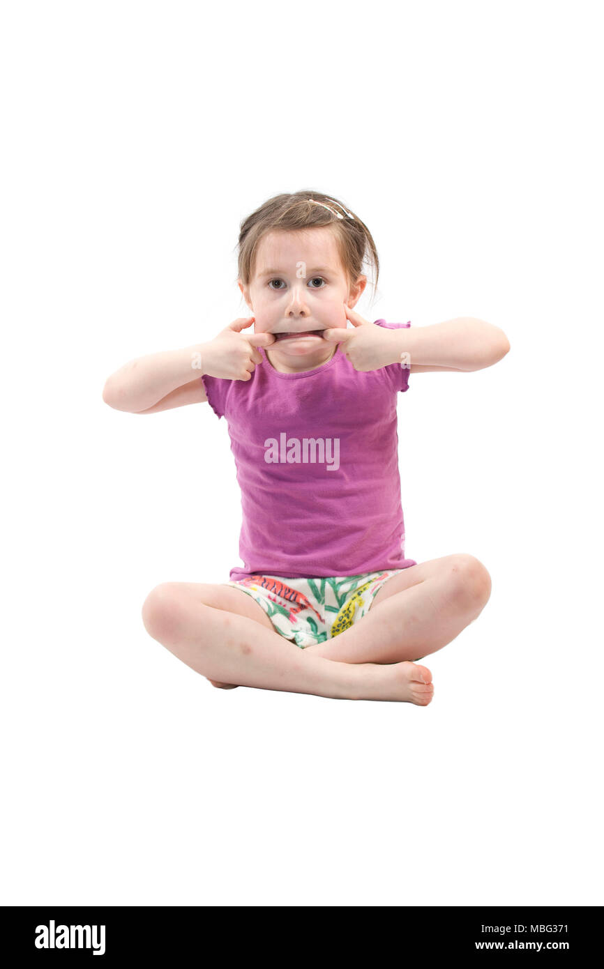 young girl sat on floor pulling a face Stock Photo