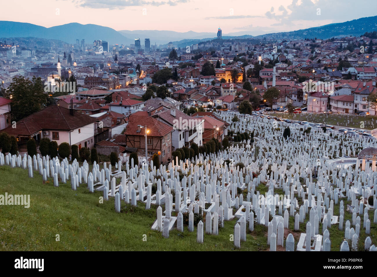 Looking out over the beautiful city of Sarajevo at sunset from Žuta Tabija (Yellow Fortress). The Kovači Cemetery can be seen in the foreground Stock Photo