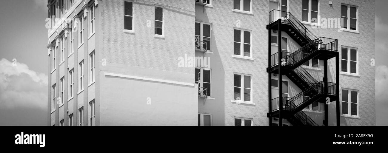 Ein Kontrast zwischen einem modernen schwarzen Iron Fire escape auf einem Vintage White Backsteingebäude in Hattiesburg, MS, USA, in einem Format Stockfoto