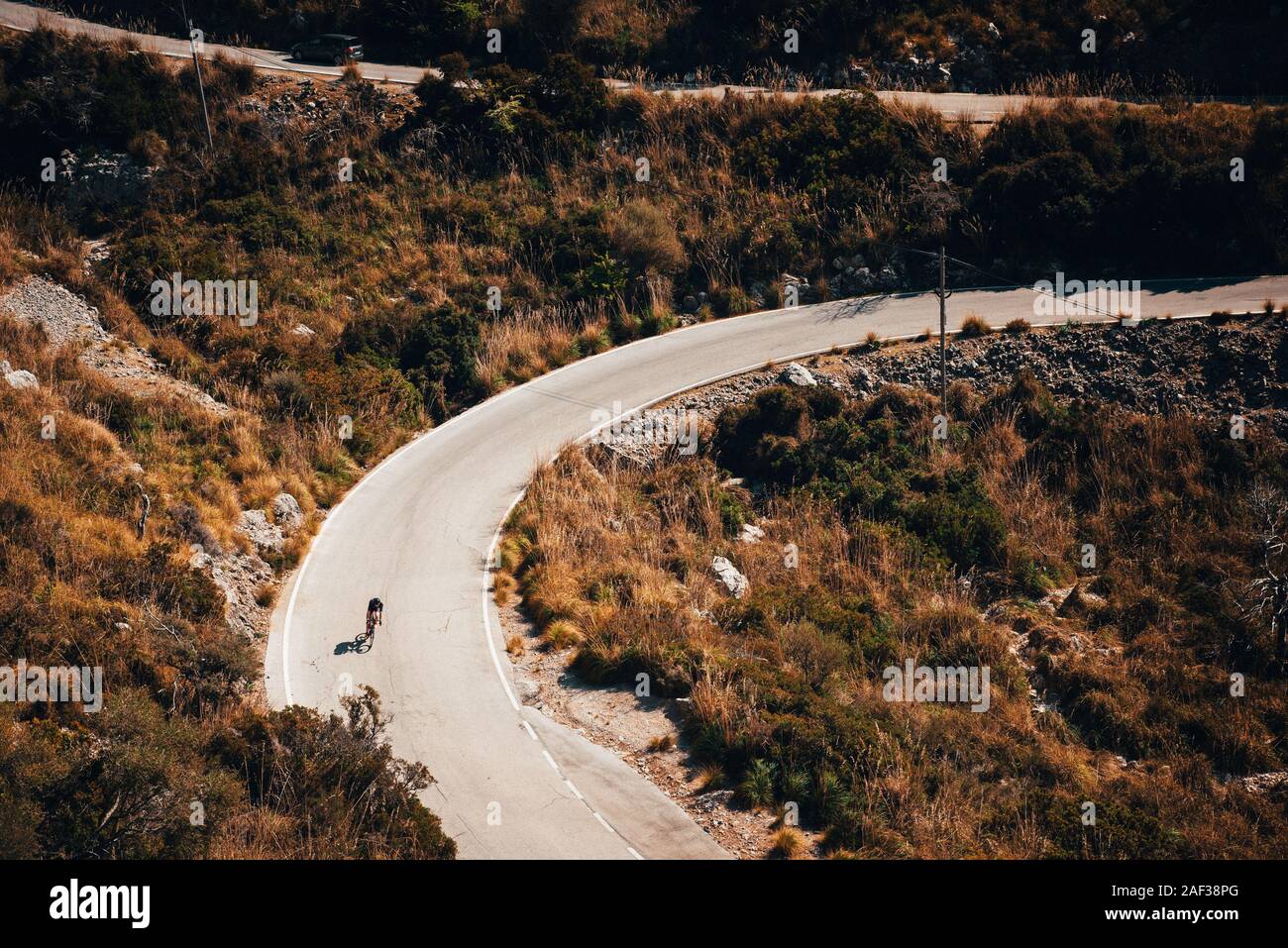 Kleine Silhouette der Reiter auf der Straße Fahrrad, Downhill am Sa Calobra, Mallorca Stockfoto