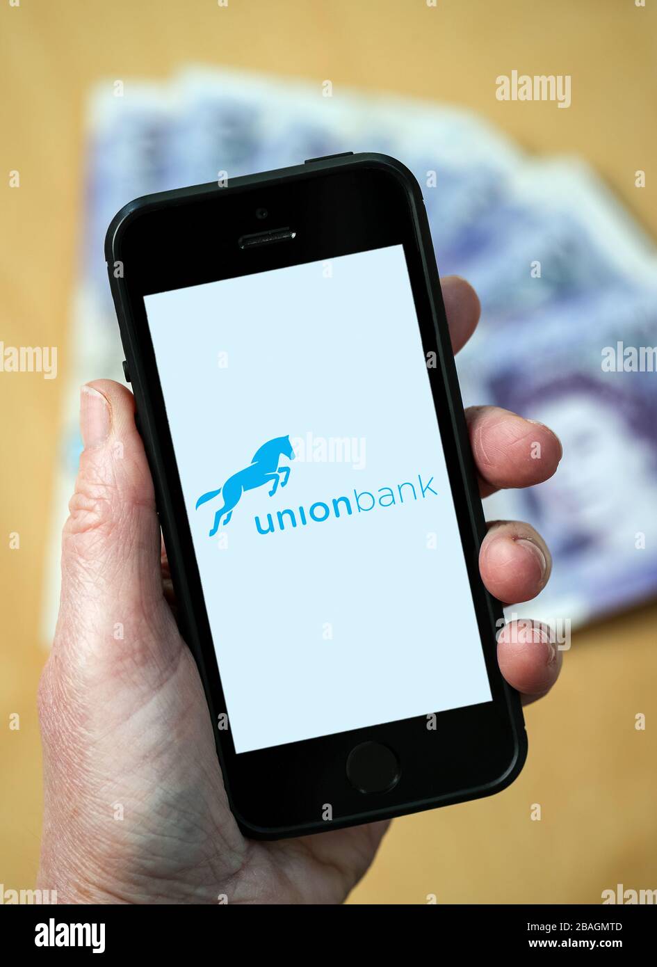 Eine Frau, die das Logo der Union Bank auf einem Handy betrachtet. (Nur redaktionelle Verwendung) Stockfoto