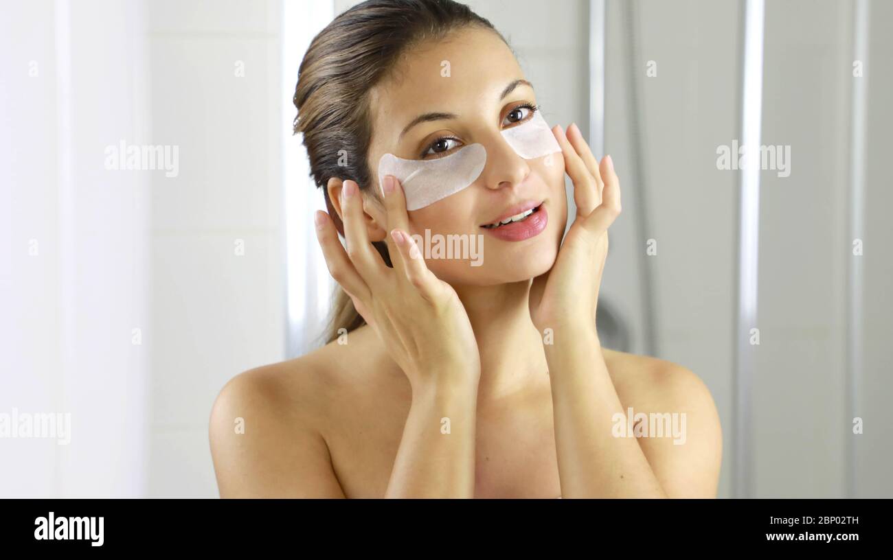 Nahaufnahme einer jungen Frau mit Flecken unter den Augen gegen Falten und dunkle Kreise. Beauty Frau Anwendung Anti-Müdigkeit unter den Augen Maske suchen sich Stockfoto