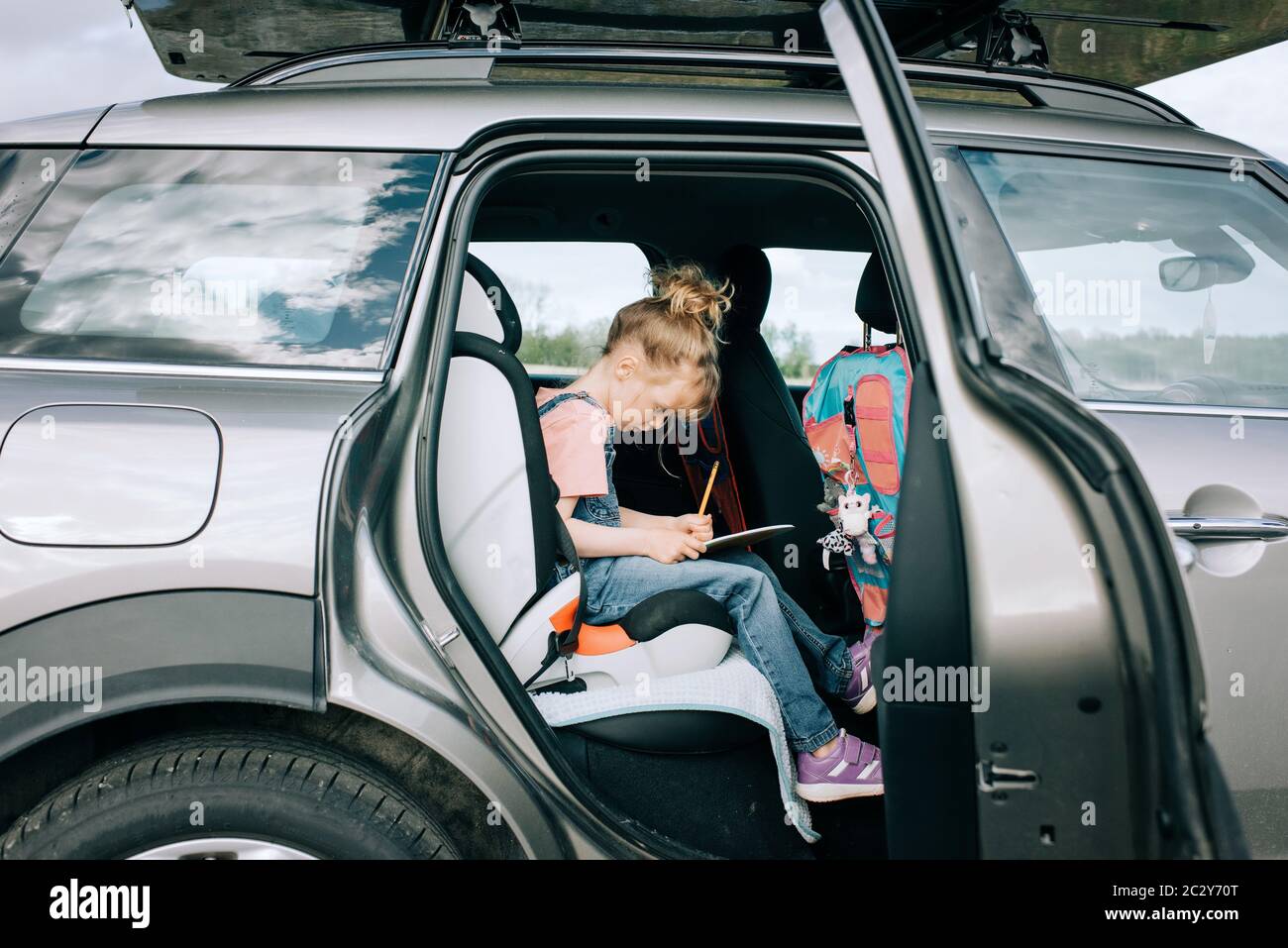 Junges Mädchen saß Zeichnung im Auto auf einer Straße Reise Stockfoto