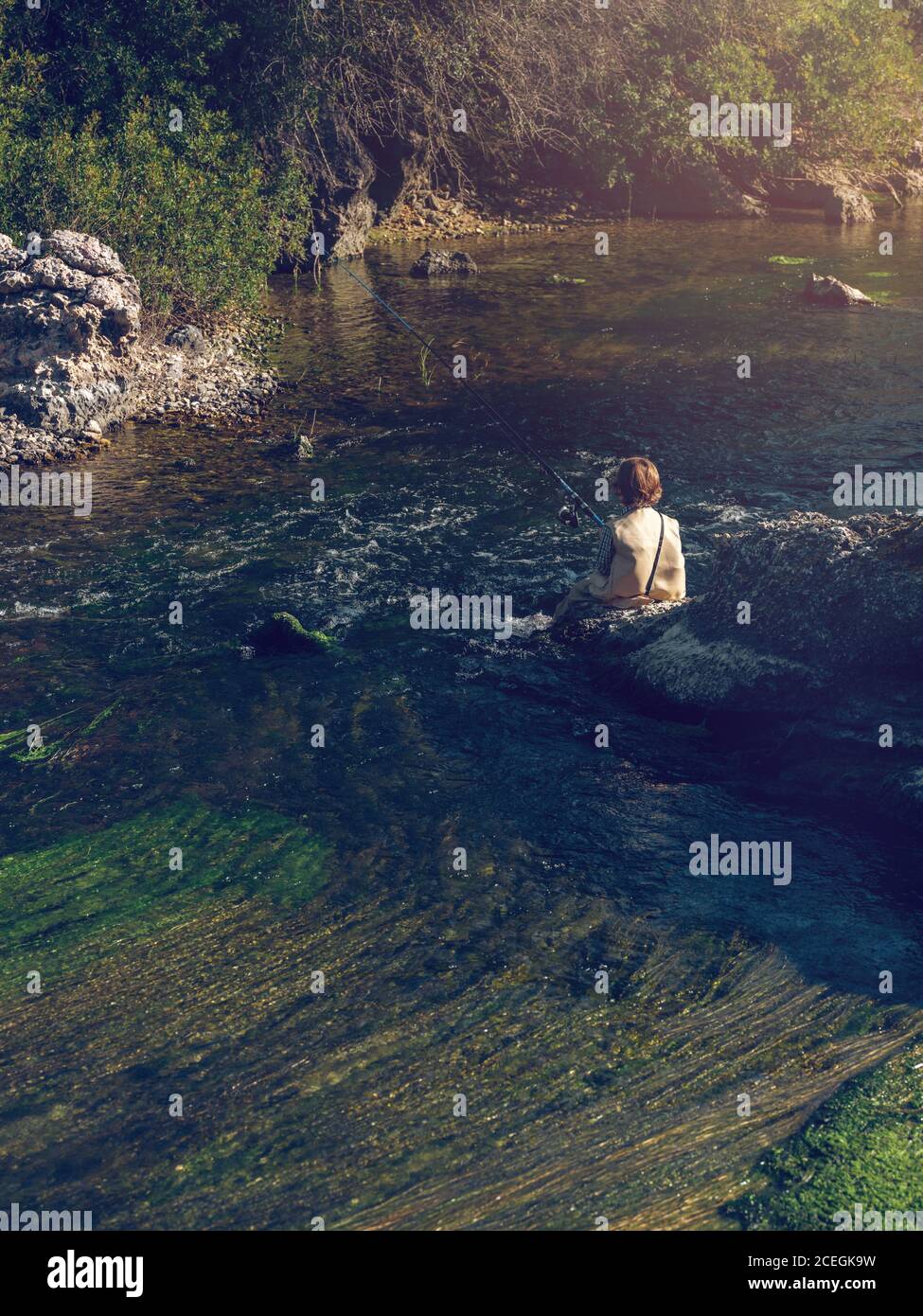 Kleiner Junge sitzt und angeln Stockfoto